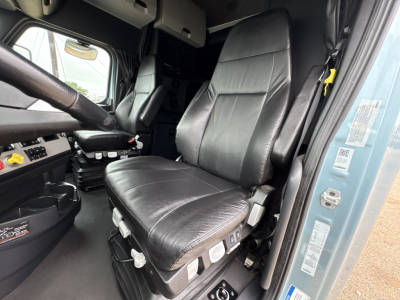 Freightliner Cascadia 126 truck cab seat and dashboard area with control switches visible