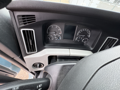 Dashboard of a Freightliner Cascadia 126 cab showing steering wheel area, instrument cluster with gauges and a central display screen.