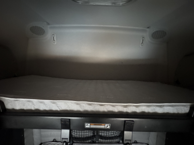Front sleeper cab interior showing a bunk bed with mattress and storage panels in a 2023 Freightliner Cascadia 126.
