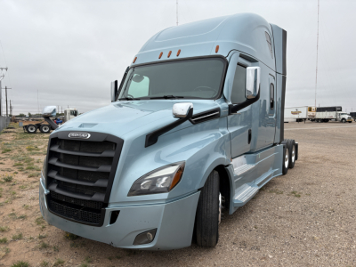 Truck cab showing Freightliner Cascadia 126 with light blue exterior, aerodynamic mirrors, and sleeper design.
