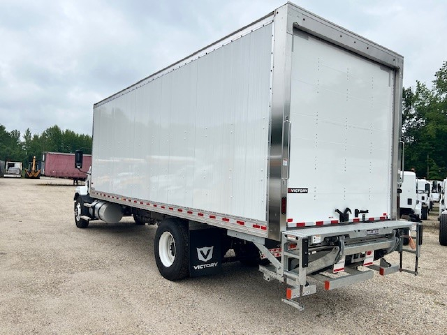 Box truck trailer attached to a Mack MD6 chassis with a large rectangular cargo box. Visible text: Victory logo on mud flaps, rear bumper with lights, hinge doors.