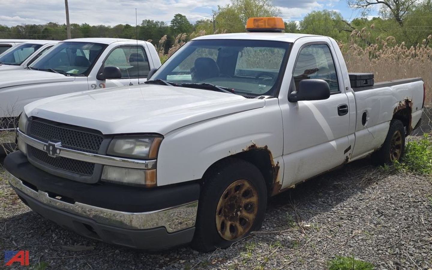 Chevrolet Silverado 1500 pickup truck in serviceable condition showing front grille, single cab, long bed, amber cab light, and rusty wheel areas.