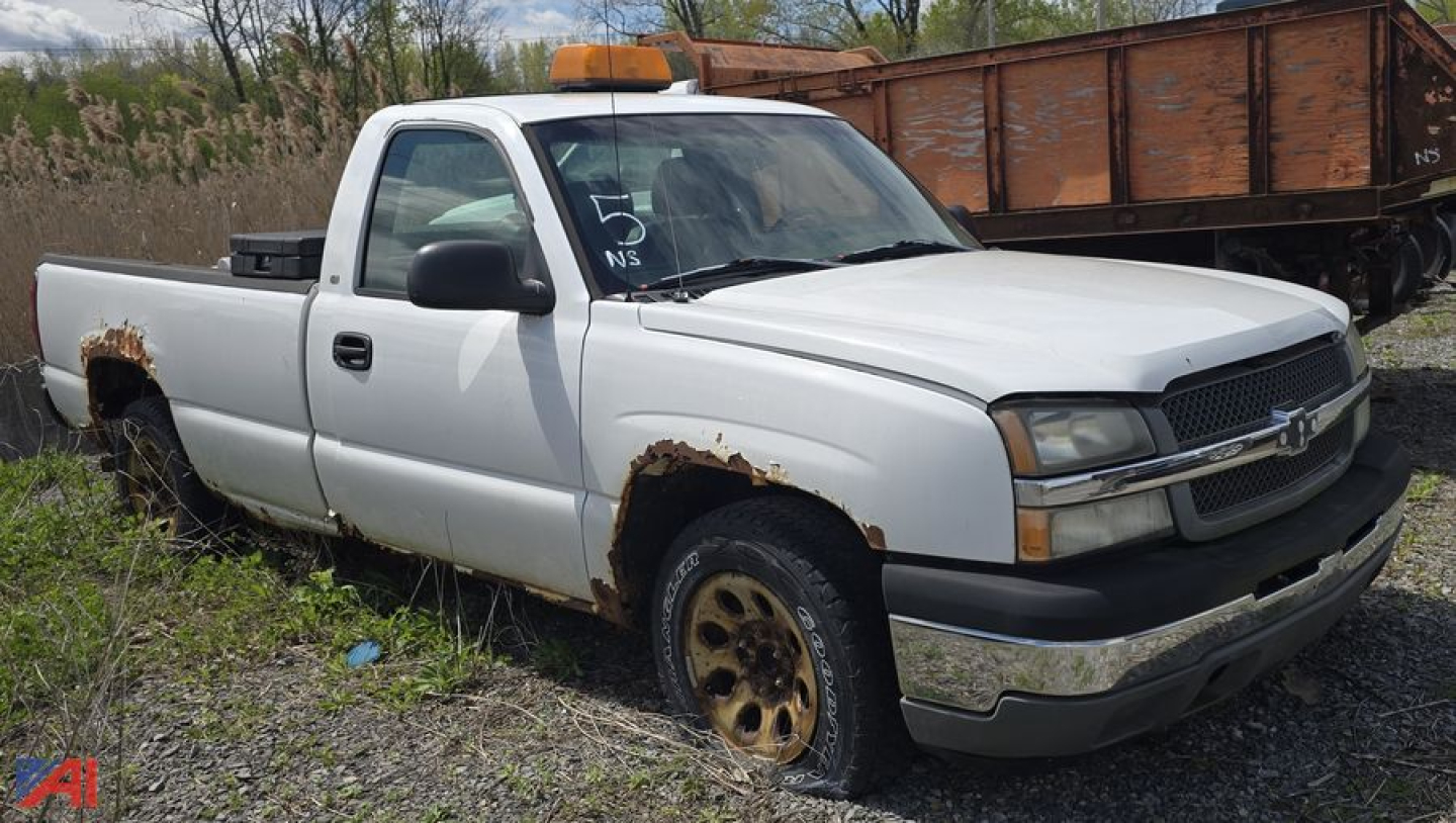 Chevrolet Silverado 1500 pickup truck in serviceable condition with visible rust on front fenders and wheel wells, two-tone white exterior, orange emergency beacon on cab, single cab long bed