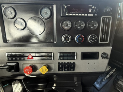 Dashboard panel of a 2023 Freightliner Cascadia 126 showing gauges, controls, knobs, warning lights, and ignition area.