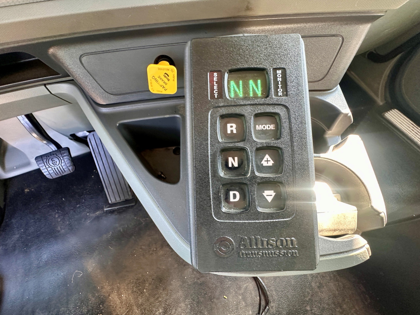 Kenworth T880 interior gear selector panel showing R N D with green N and switches labeled MODE and +/- in view
