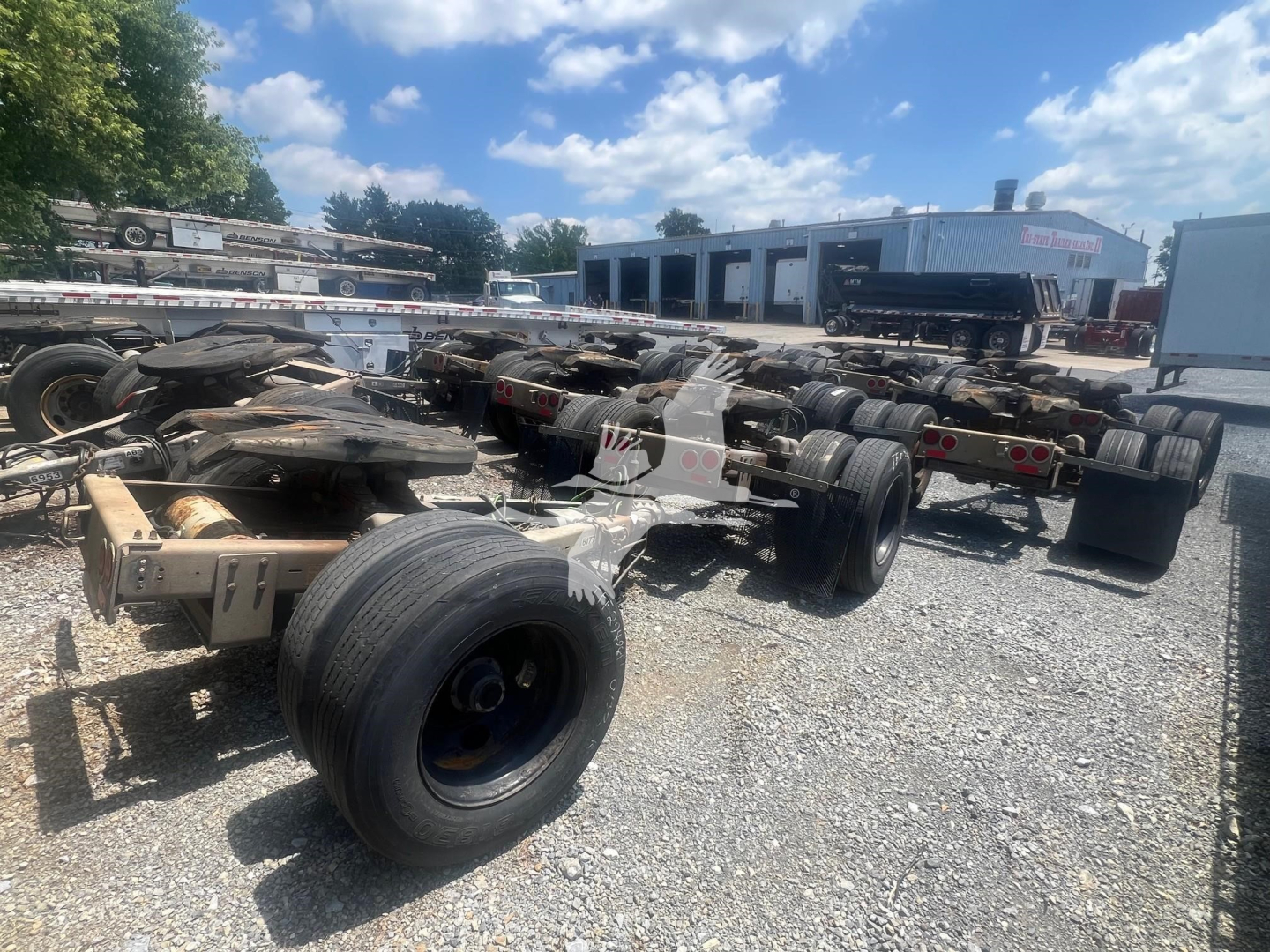 Trailer chassis with multiple axles and wheels, used Eagle Rock dolly trailer frame in outdoor lot.