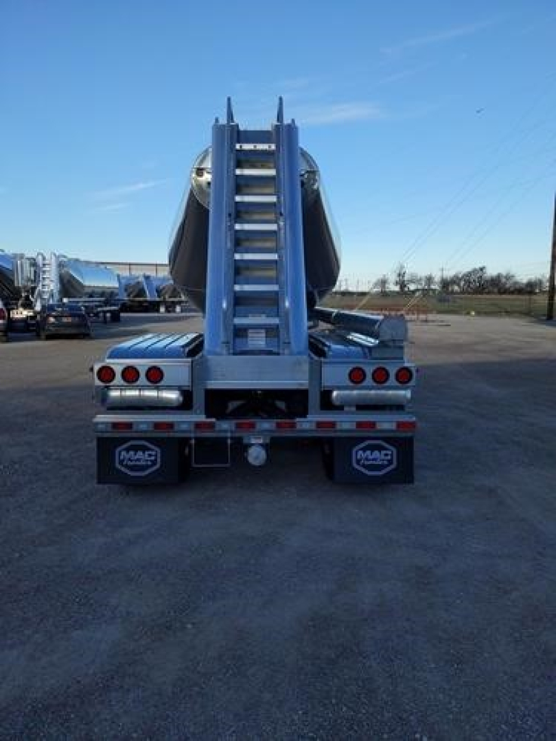 Rear view of a blue Mac Pneumatic trailer with a vertical ladder and rear lights, Mac branded mudflaps, and a double-axle configuration.
