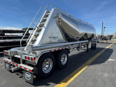 Mac Pneumatic trailer showing polished aluminum cylindrical tank with rear and side view, stairs and railing, dual rear axles, and MACs branding plate.