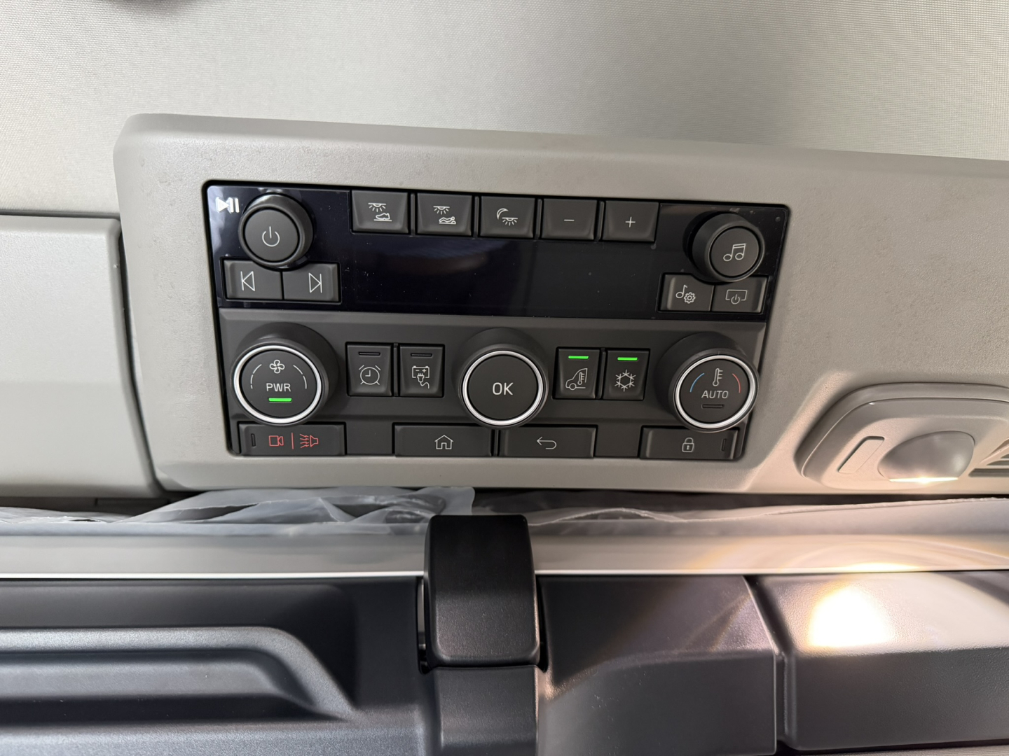Dashboard control panel of a Volvo truck cab showing climate controls, audio buttons, and radio/overhead panel in view.