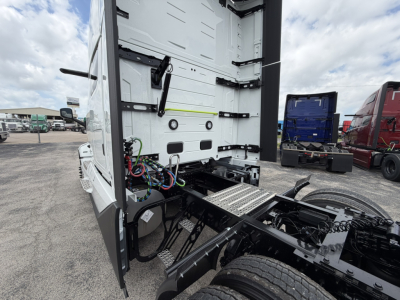 Rear view of a Volvo VNL truck in a lot showing the rear cab and trailer connection area with wiring harnesses, chassis, and steps.