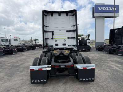 Volvo semi truck tractor rear view showing fifth wheel, dual rear axles, and mudflaps with Volvo logo.