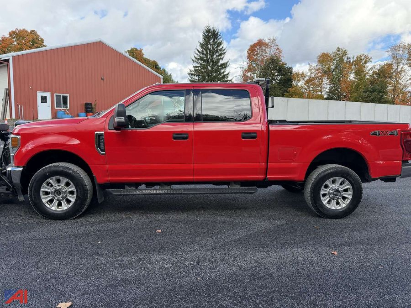 Ford F-250 Super Duty pickup truck side view in red with crew cab and long bed, 4x4 badge visible, plow-ready heavy-duty vehicle.