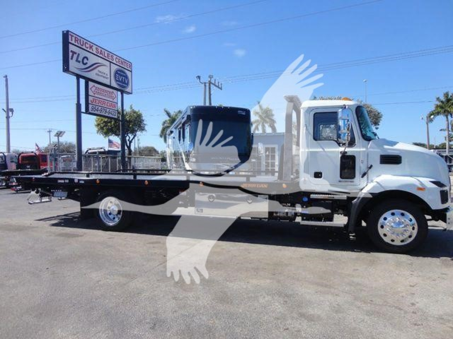 MD6 heavy-duty truck flatbed at a dealer lot, side view showing long flatbed and cab with chrome wheels