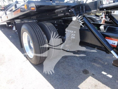 Tractor trailer rear view showing dual rear tires and part of a Mack MD6 rollback equipment frame with warning label. Stock and category text not visible on image.