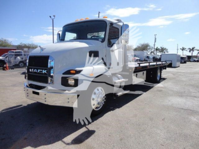 Mack MD6 rollback truck in a dealership lot, front-left view, white cab, flatbed with wheel lift, stock number WHTMACKMD6 visible in listing.