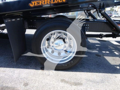 Wheel and front section of a Mack MD6 rollback truck showing chrome wheel, black frame, and Jerr-Dan branding.