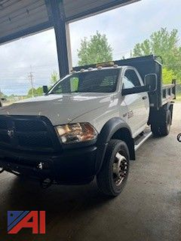 RAM 5500 dump truck in a showroom setting showing front-left view with dump bed.