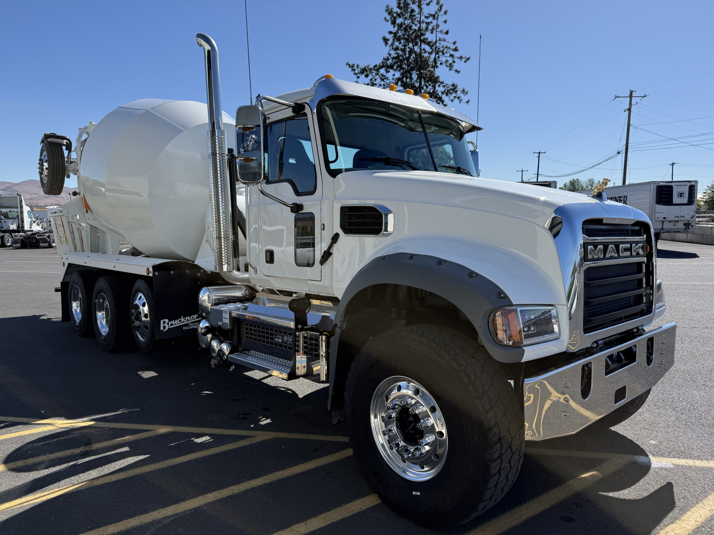 Mack GR84F cement mixer truck in white showing front grille, cab with chrome bumper, and mixer drum