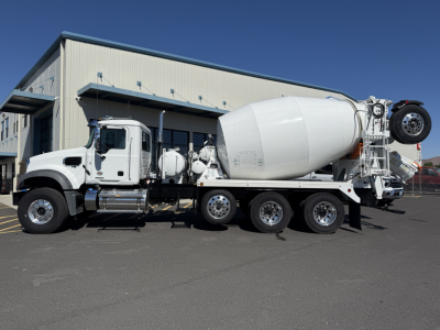Concrete mixer truck with a white cab and large rotating drum, side view showing mixer body and rear wheel assembly.