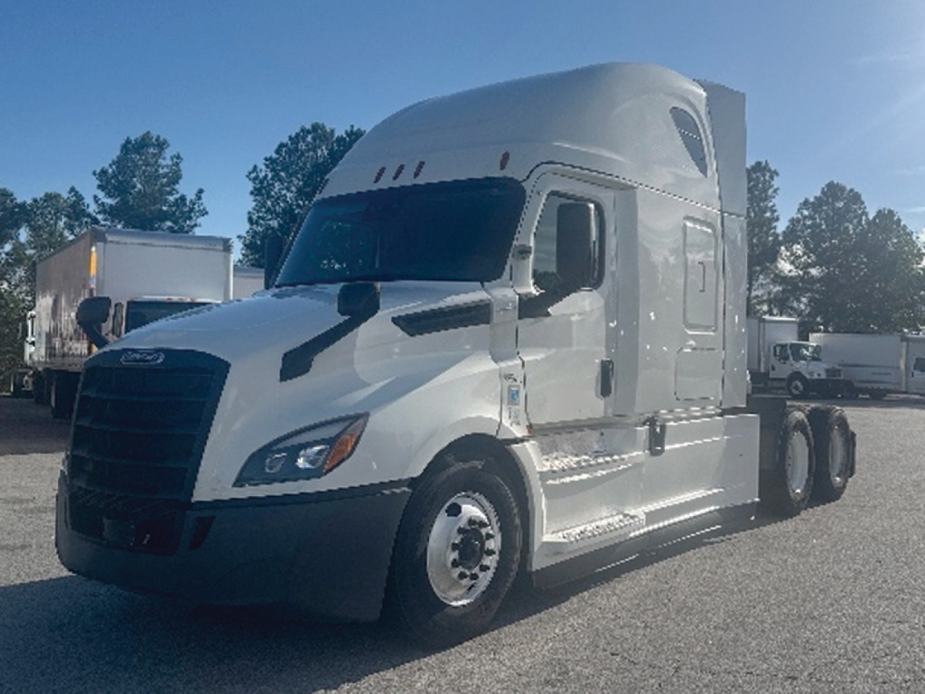 Freightliner Cascadia 126 sleeper tractor in a lot showing front-left view with silver/gray paint and aerodynamic cab.