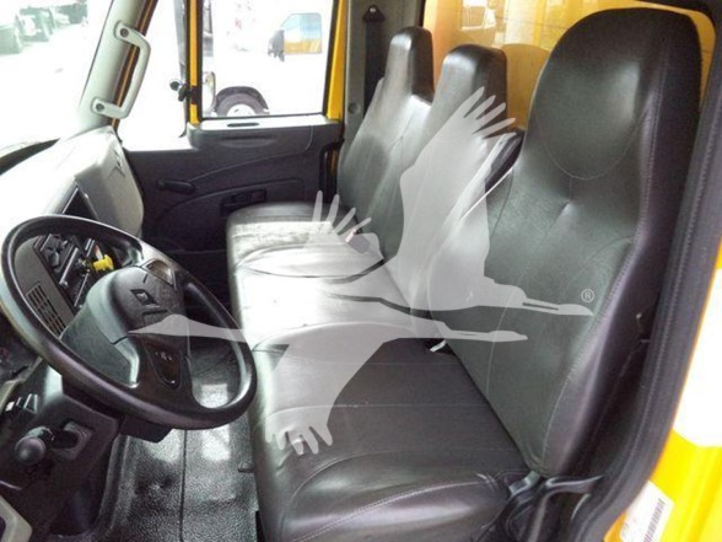 Truck cab interior with three seats, steering wheel, and dashboard visible.