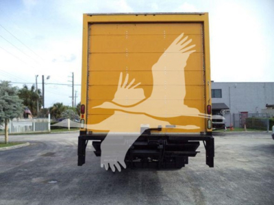 Rear view of a yellow box truck with a large white bird graphic on the back doors and black bumper undercarriage.