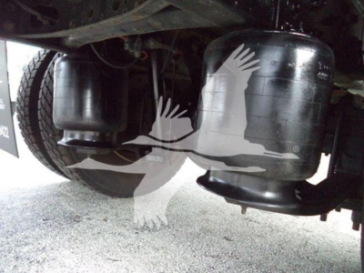 Under-chassis view of a 2018 International Durastar 4300 showing two large cylindrical air tanks/filters and part of the wheel; no readable text visible.