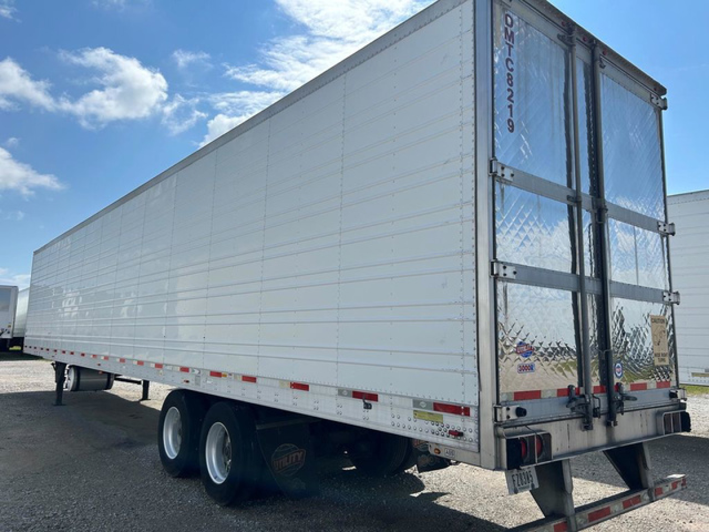 Trailer side view of a 2018 utility refrigerated trailer with white aluminum walls and dual rear doors, stock U90767, VIN 1UYVS2538J2238216.