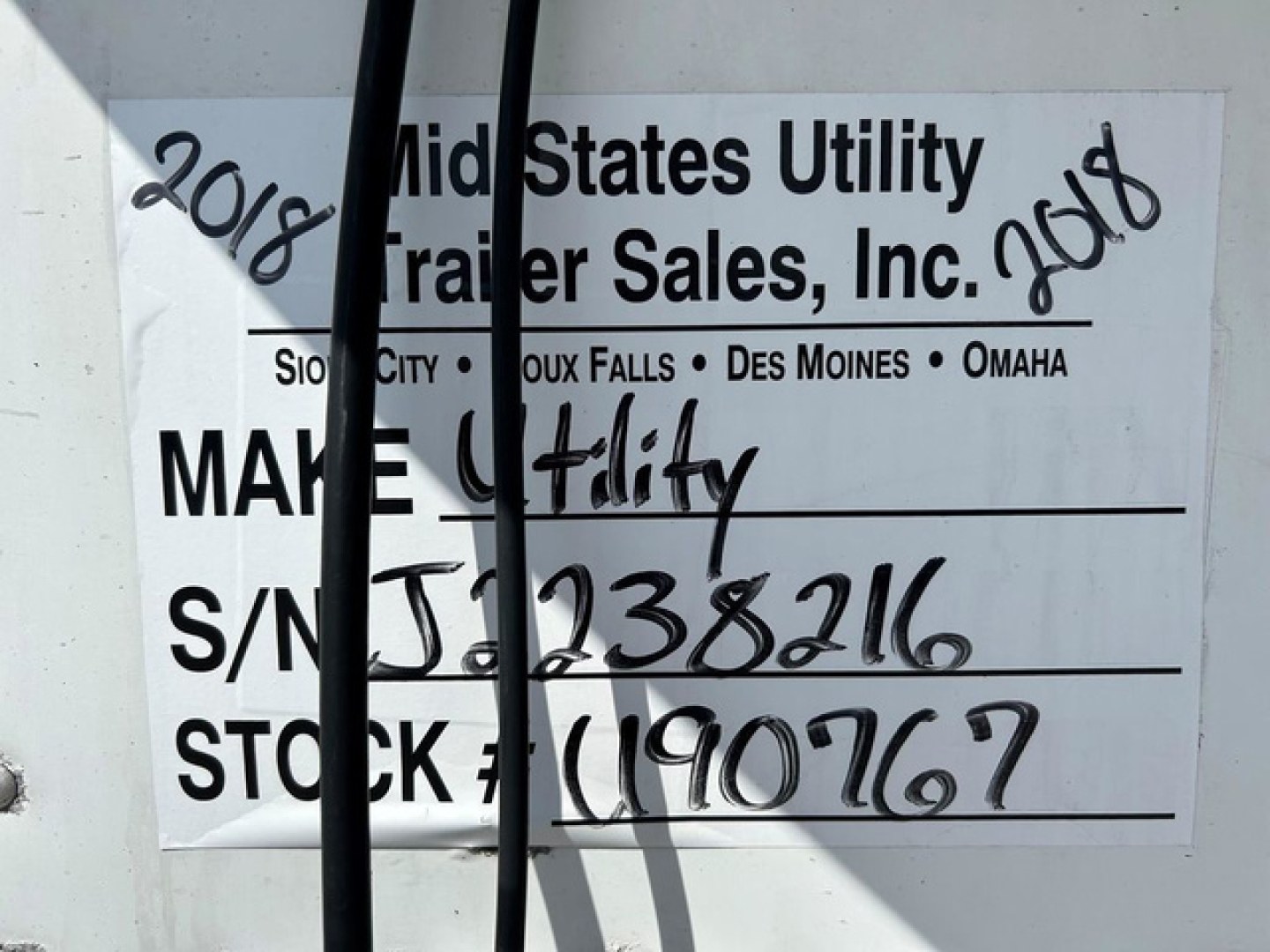 Refrigerated trailer identification tag showing stock and VIN details with handwritten year 2018 on sides.