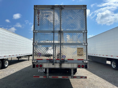 Reefers trailer rear view showing metal doors with diamond plate, rear lights, bumper, and safety stickers.