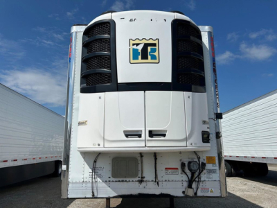 Refrigerated trailer front view showing Thermo King unit with company logo, side skirts, and bumper area; VIN and stock not visible, utility reefer trailer.