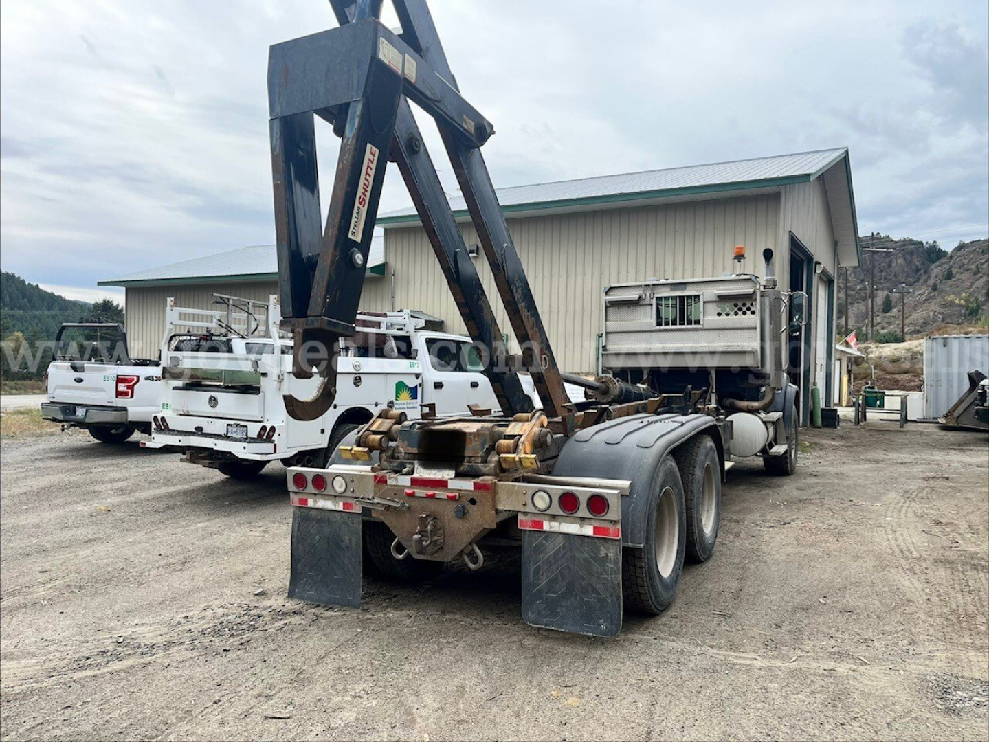 Sterling LT9500 roll-off truck rear view showing dual rear axles, towing apparatus, and trailer hitch and mud flaps.