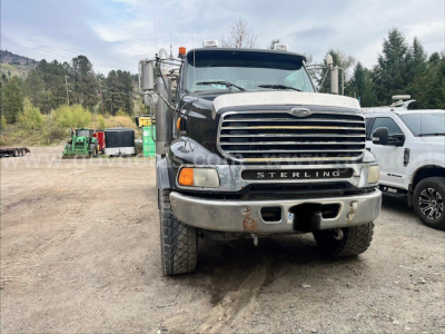 Sterling LT9500 front view showing large chrome grille, bumper, dual headlights, and heavy-duty tires; ‘STERLING’ badge on grille; equipment truck for roll-off category.