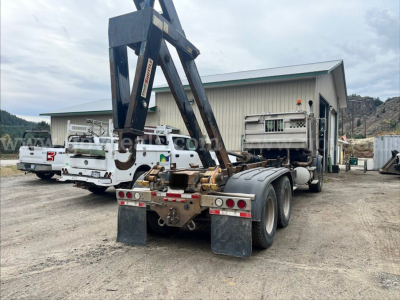 Sterling LT9500 roll-off truck rear view showing dual rear axles, towing apparatus, and trailer hitch and mud flaps.