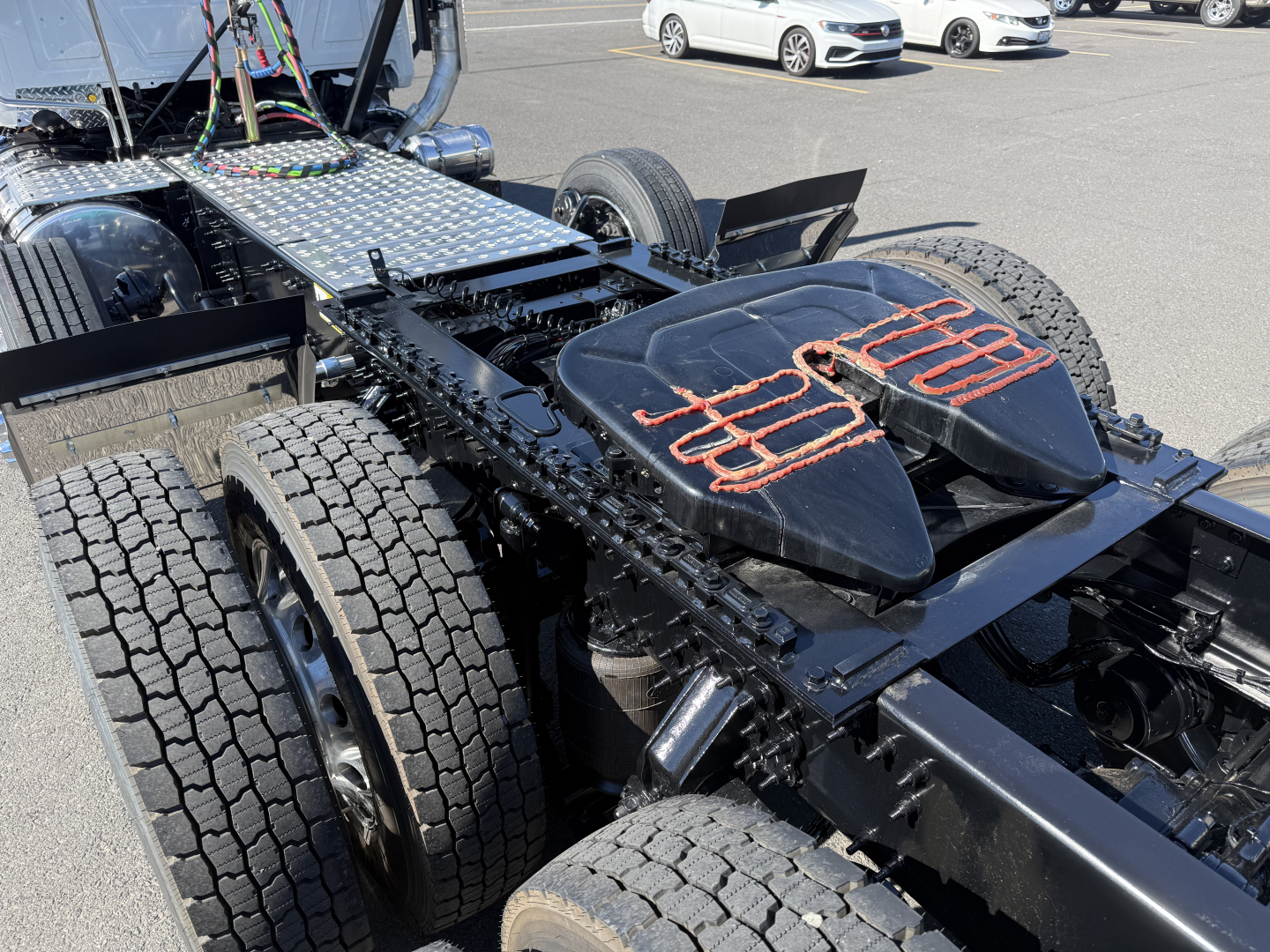 Mack PI84T tractor chassis showing dual rear axles and fifth-wheel area with seating pads and metal steps.