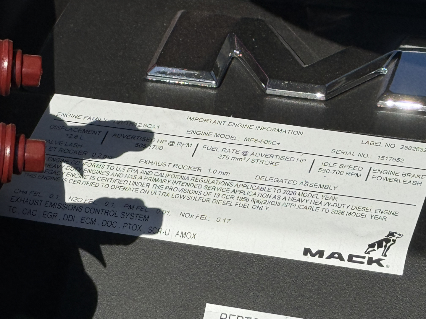 Mack PI84T engine cover showing engine information label with serials and specs, including engine model and RPM limits.