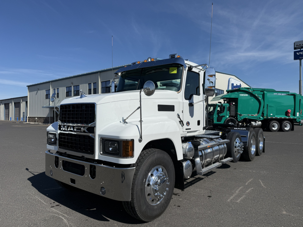 Mack PI84T conventional daycab truck in white with chrome bumper and dual rear axles, parked in lot.