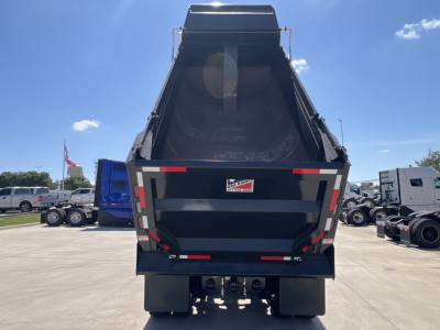 Dump truck bed of a 2027 Mack PI64 rear view showing dumping bed and taillights.