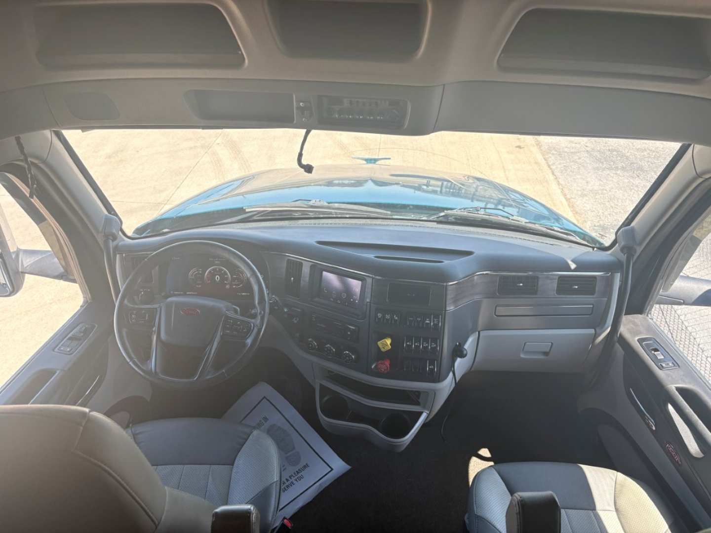 Peterbilt 579 cab interior view showing dashboard, steering wheel, and controls in a sleeper truck.