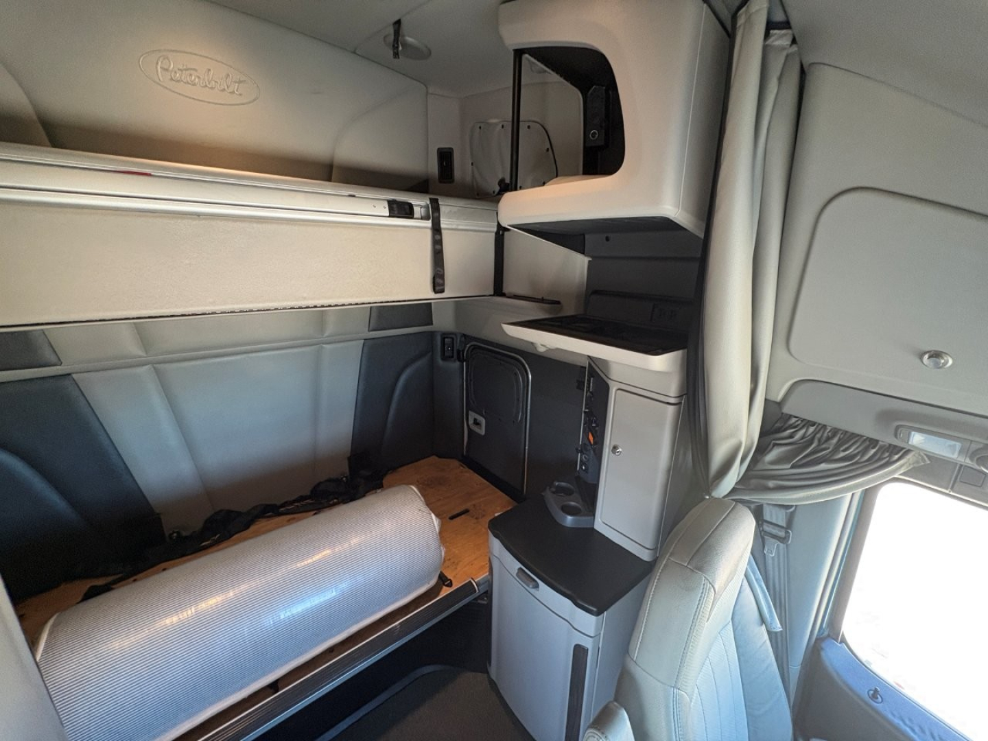 Peterbilt 579 truck cab interior showing sleeper area with storage compartments and cabinetry.
