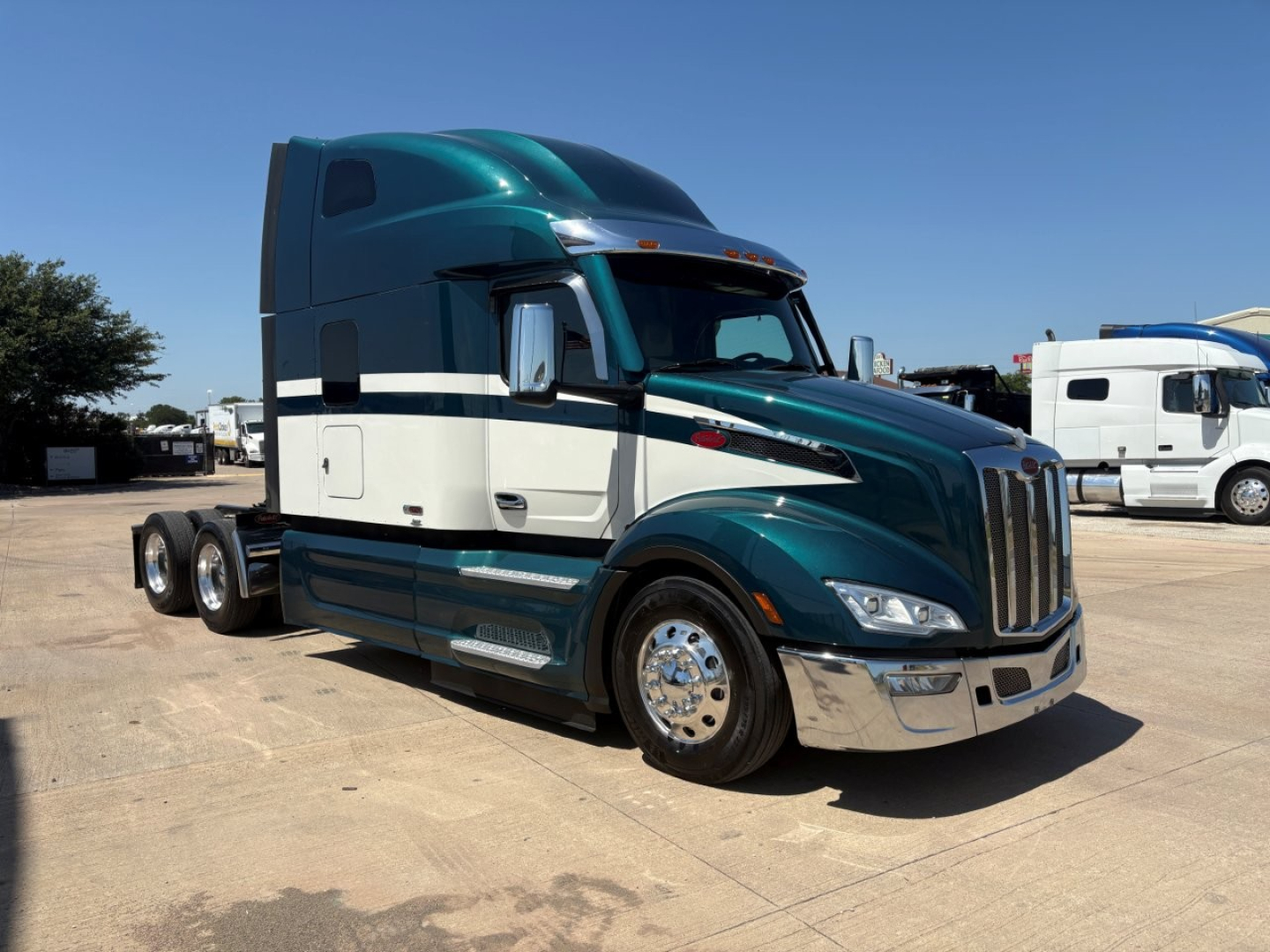 Peterbilt 579 tractor-trailer in teal and white, side view, long sleeper cab, chrome wheels, 3-axle configuration, visible VIN tag in listing context.