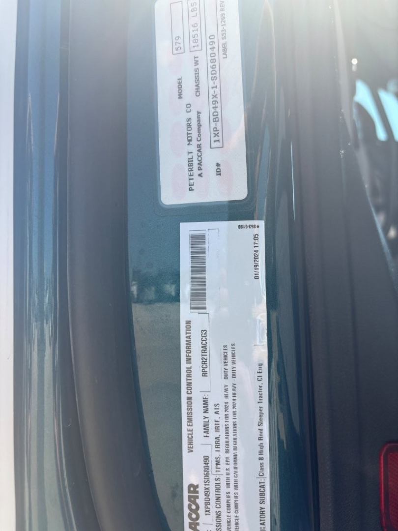 Vehicle identification label and spec stickers on a Peterbilt 579 door jamb showing VIN 1XPBD49X1SD680490 and stock B3750P along with barcodes.