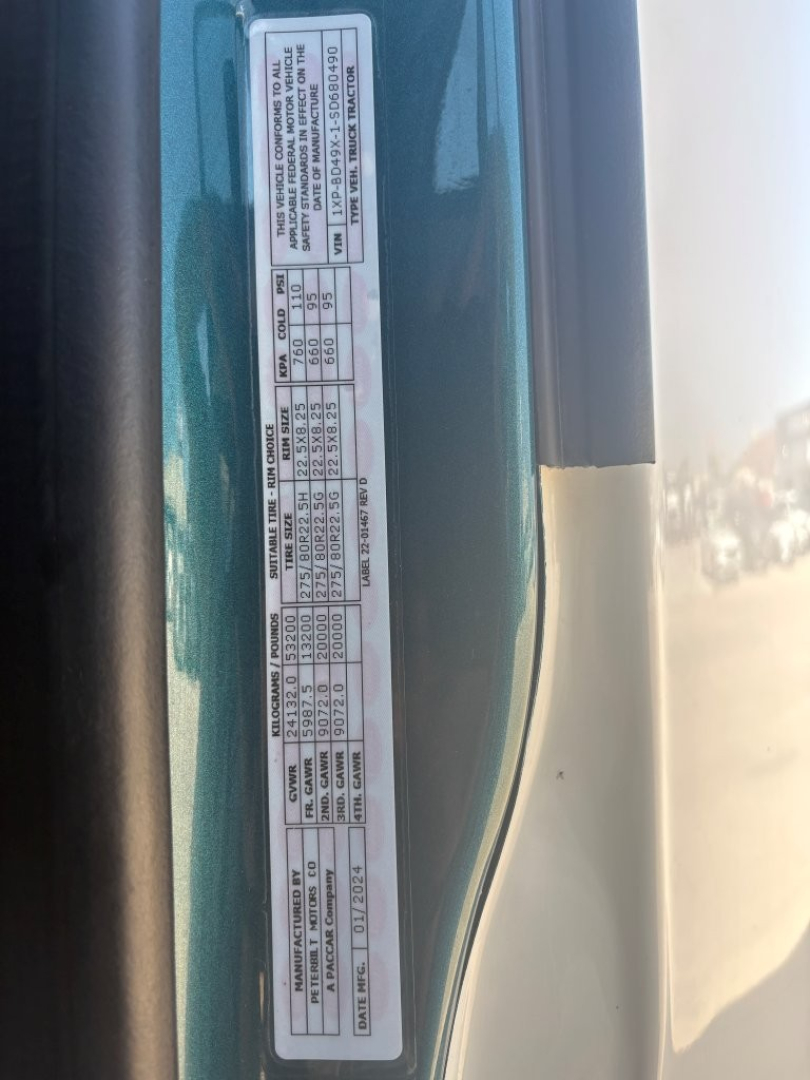 Label plate on Peterbilt truck door with various specifications and VIN sticker text oriented vertically.