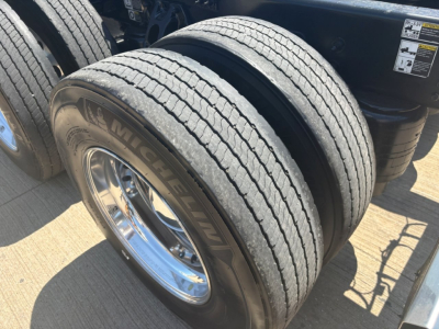 Michelin dual rear truck tires on a 2025 Peterbilt 579 conventional sleeper chassis showing tread, rims, and wheel wells.