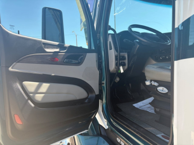 Cab interior of a Peterbilt 579 truck showing open driver door, steering wheel, and dashboard from a near-side view.