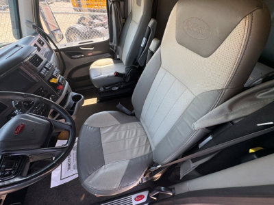 Peterbilt 579 truck interior showing driver's seat and dashboard with steering wheel and control panel.