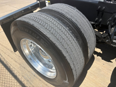 Peterbilt 579 truck rear dual tires view showing wheel, tire sidewall markings, and chassis frame.