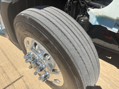 Peterbilt 579 front wheel and tire close-up showing dual rear wheels and hub with lug nuts.