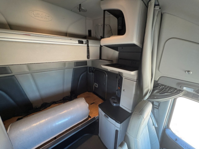 Peterbilt 579 truck cab interior showing sleeper area with storage compartments and cabinetry.