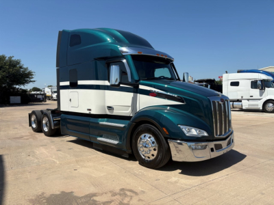 Peterbilt 579 tractor-trailer in teal and white, side view, long sleeper cab, chrome wheels, 3-axle configuration, visible VIN tag in listing context.